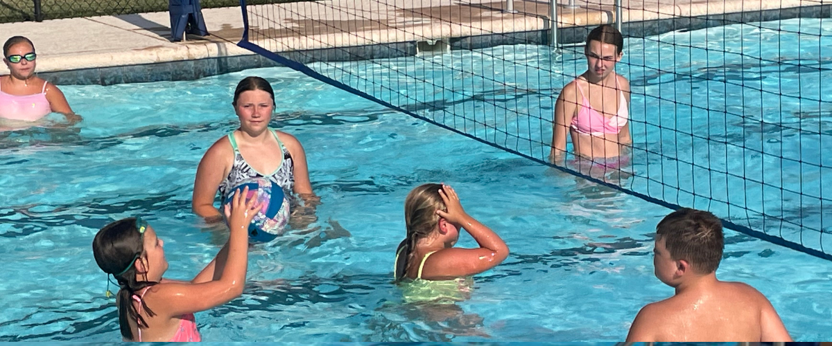 People playing volleyball in community pool